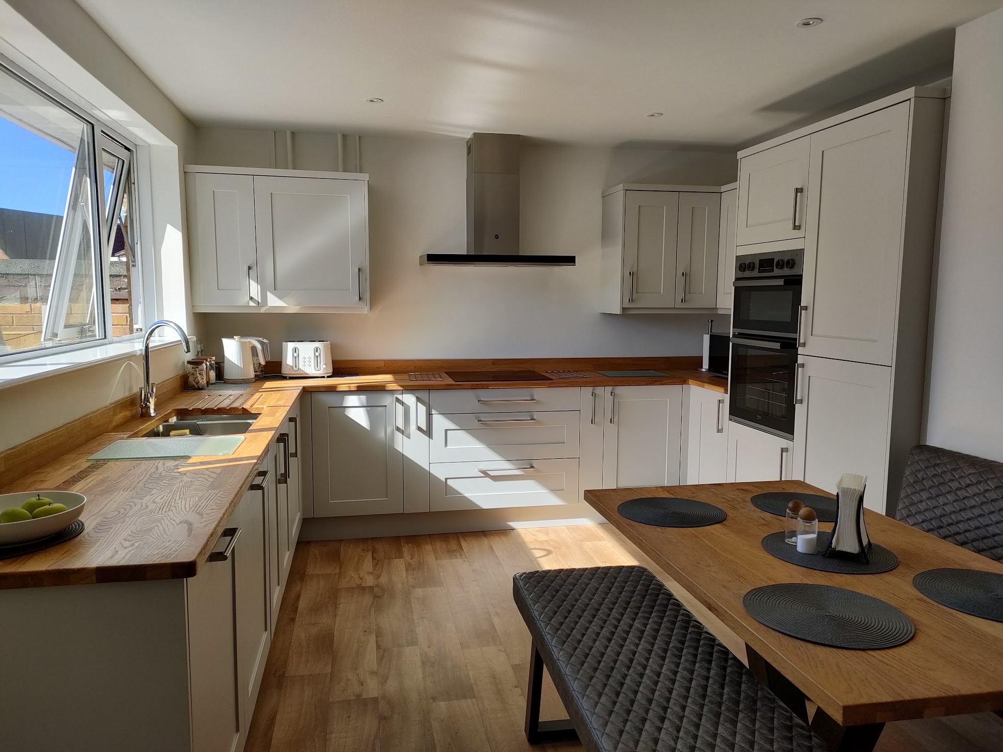 Cream shaker kitchen with oak worktops and a dining table